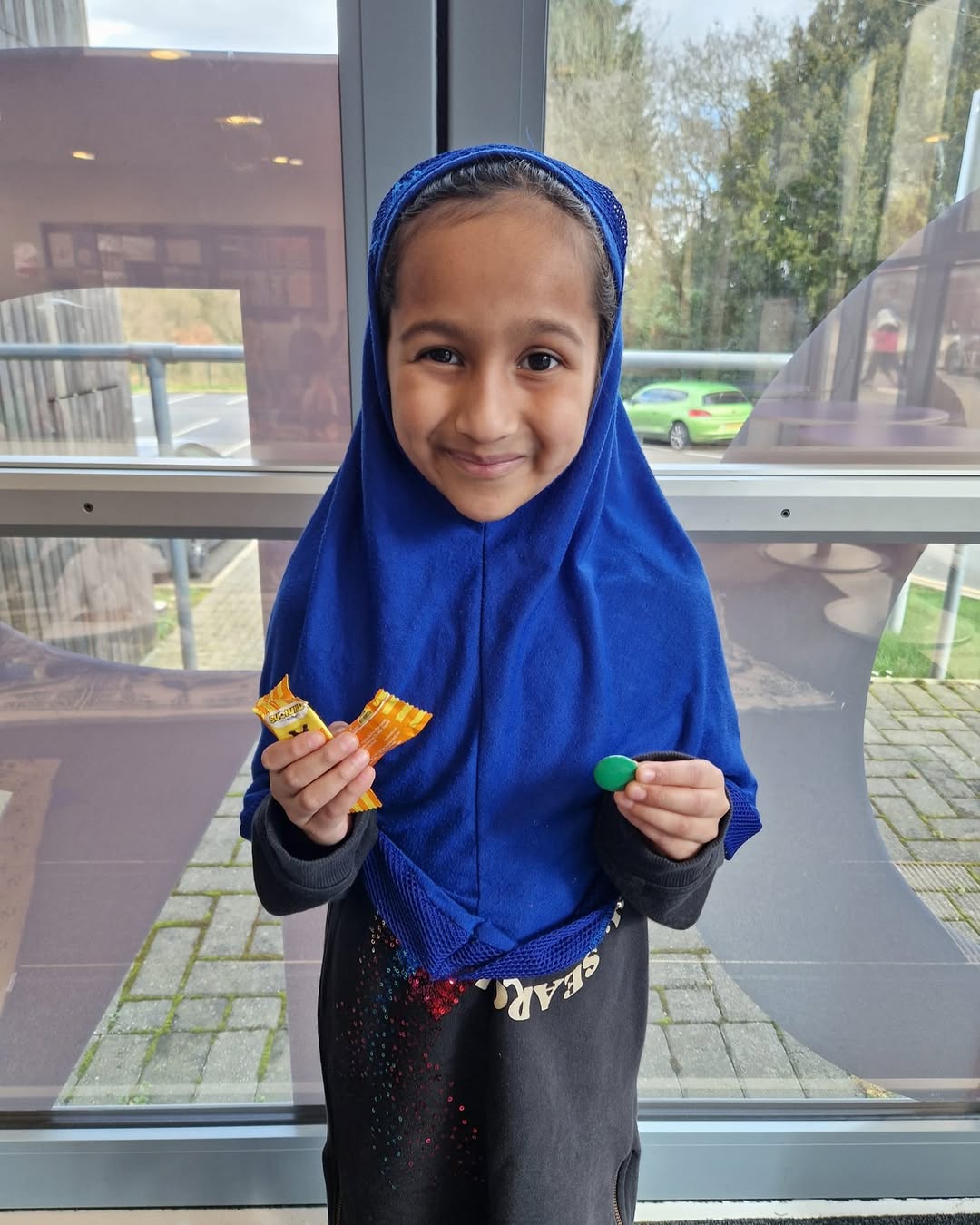 Khadijah holding her green badge