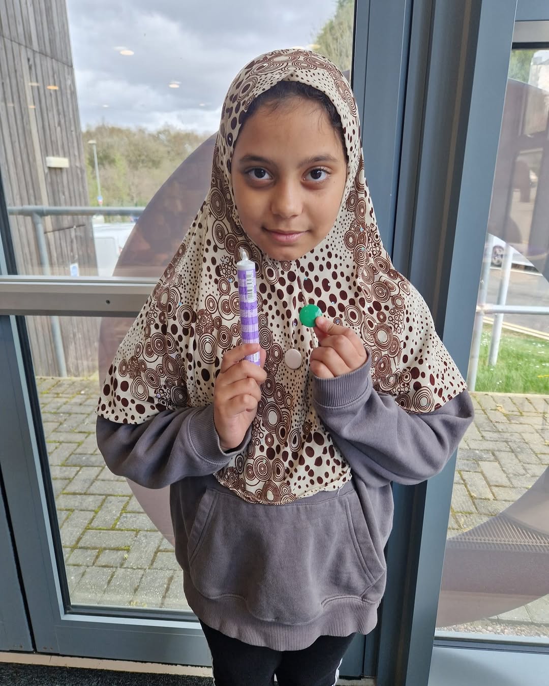 Maryam holding the Green badge