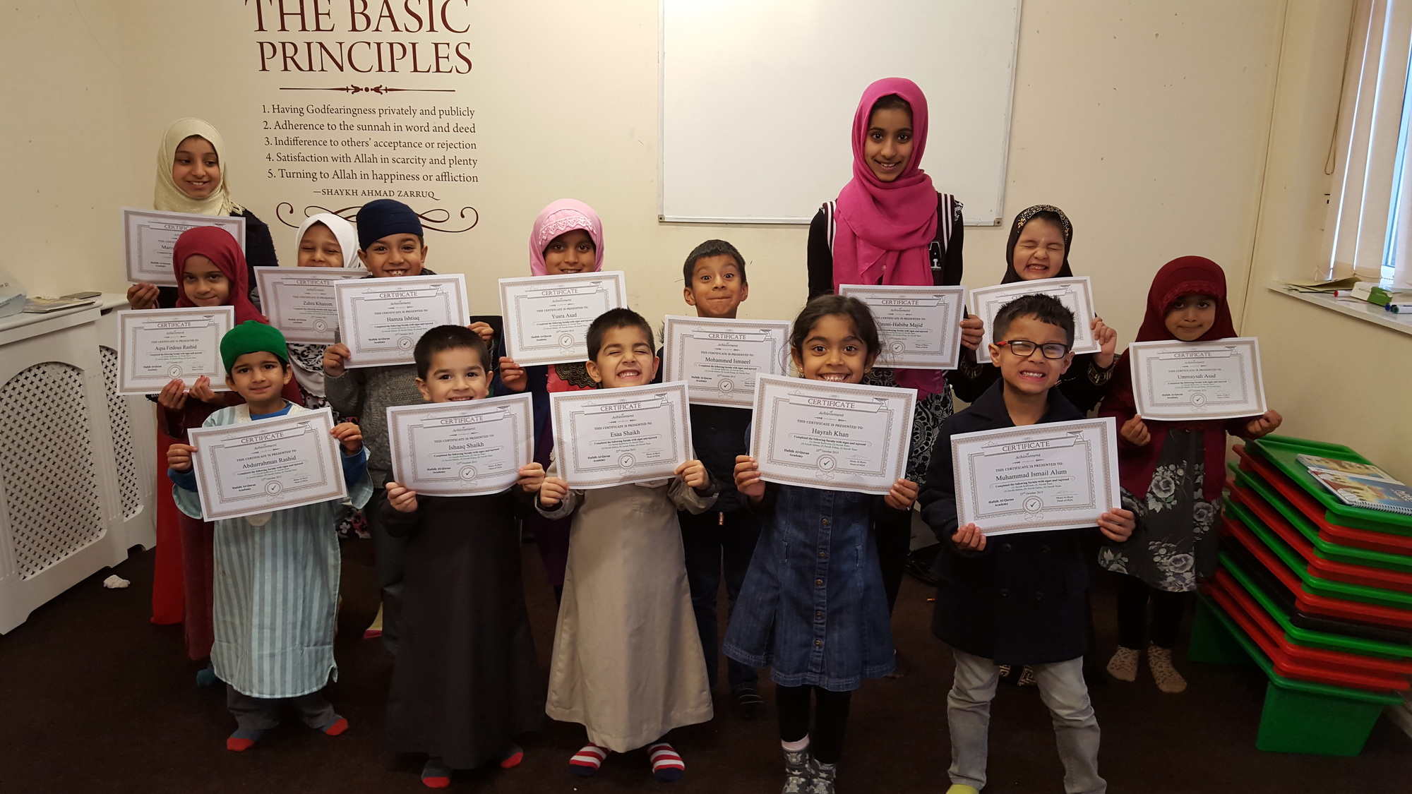 A class of smiling students holding their certificates